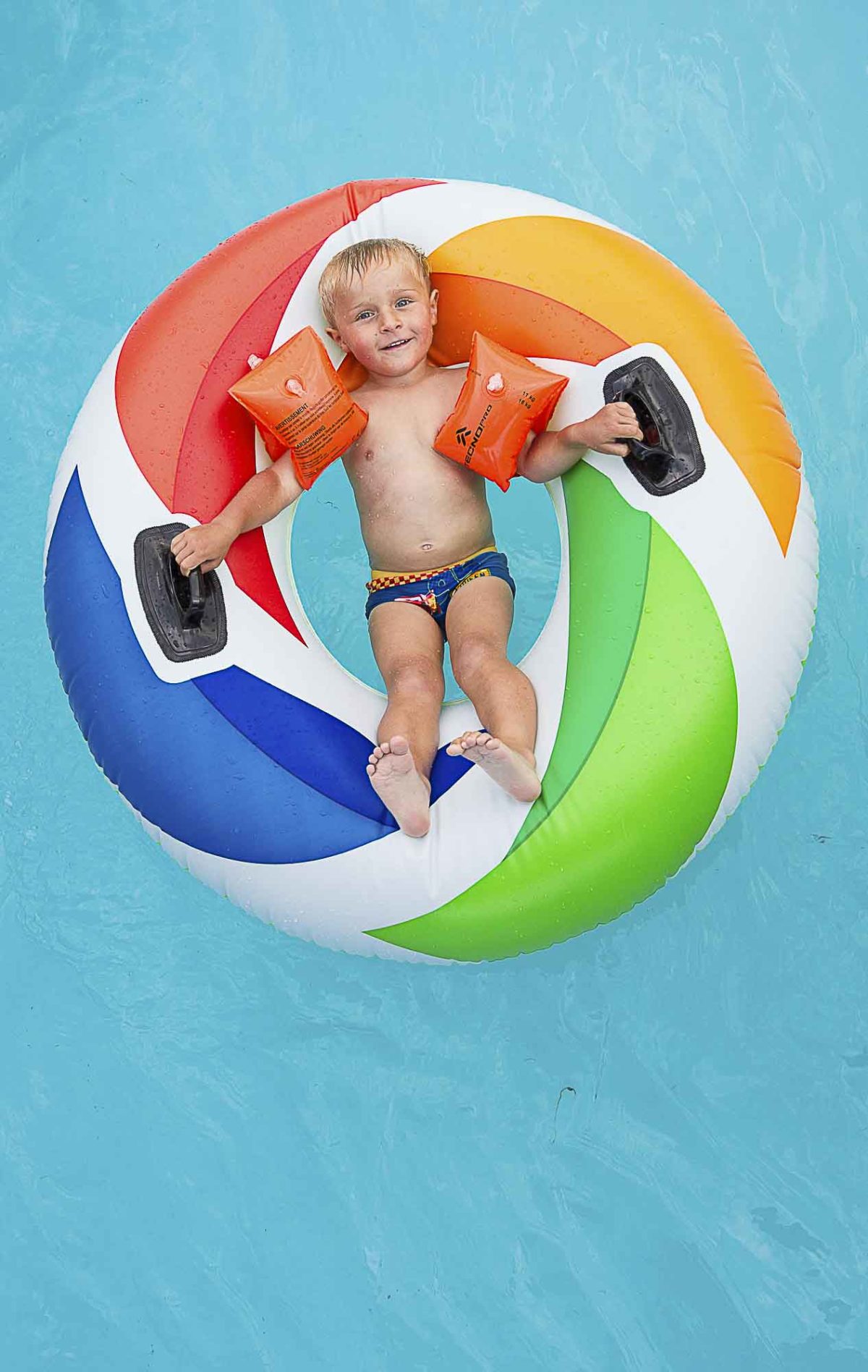 Enfant dans la piscine du camping avec une bouée