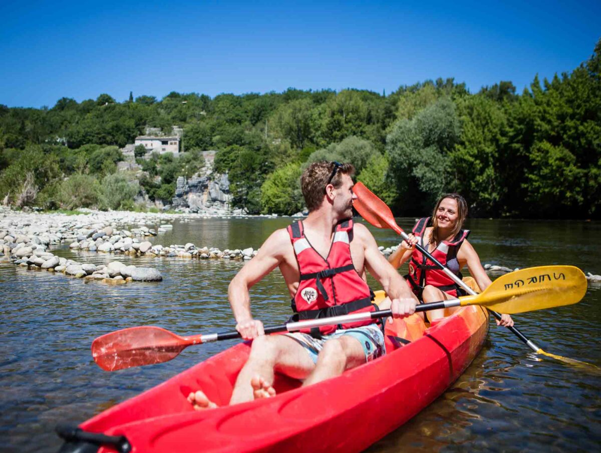 Photographie d'un couple en canoë au départ d'un camping