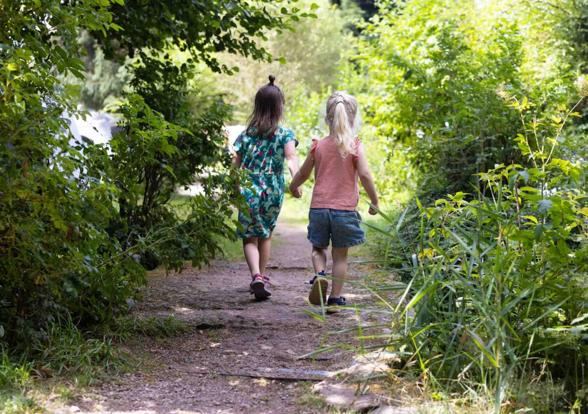 Photoghraphie de deux petites filles marchant main dans la main sur un camping